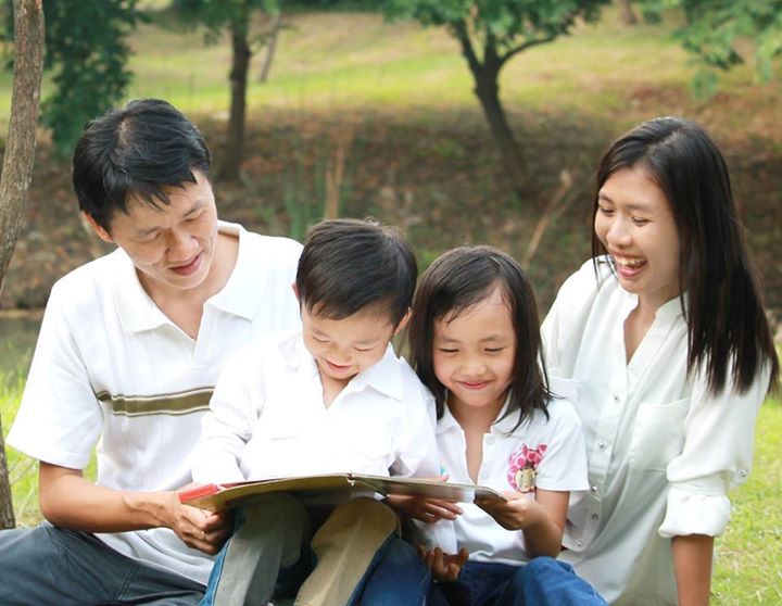 Keluarga membaca buku bersama di ruang tamu