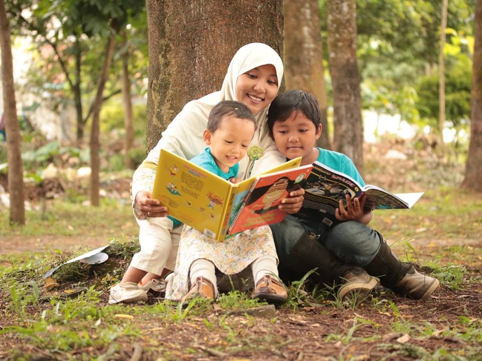 Anak membaca buku bersama orang tua