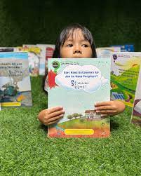 Anak membaca buku sains anak dengan ilustrasi warna-warni